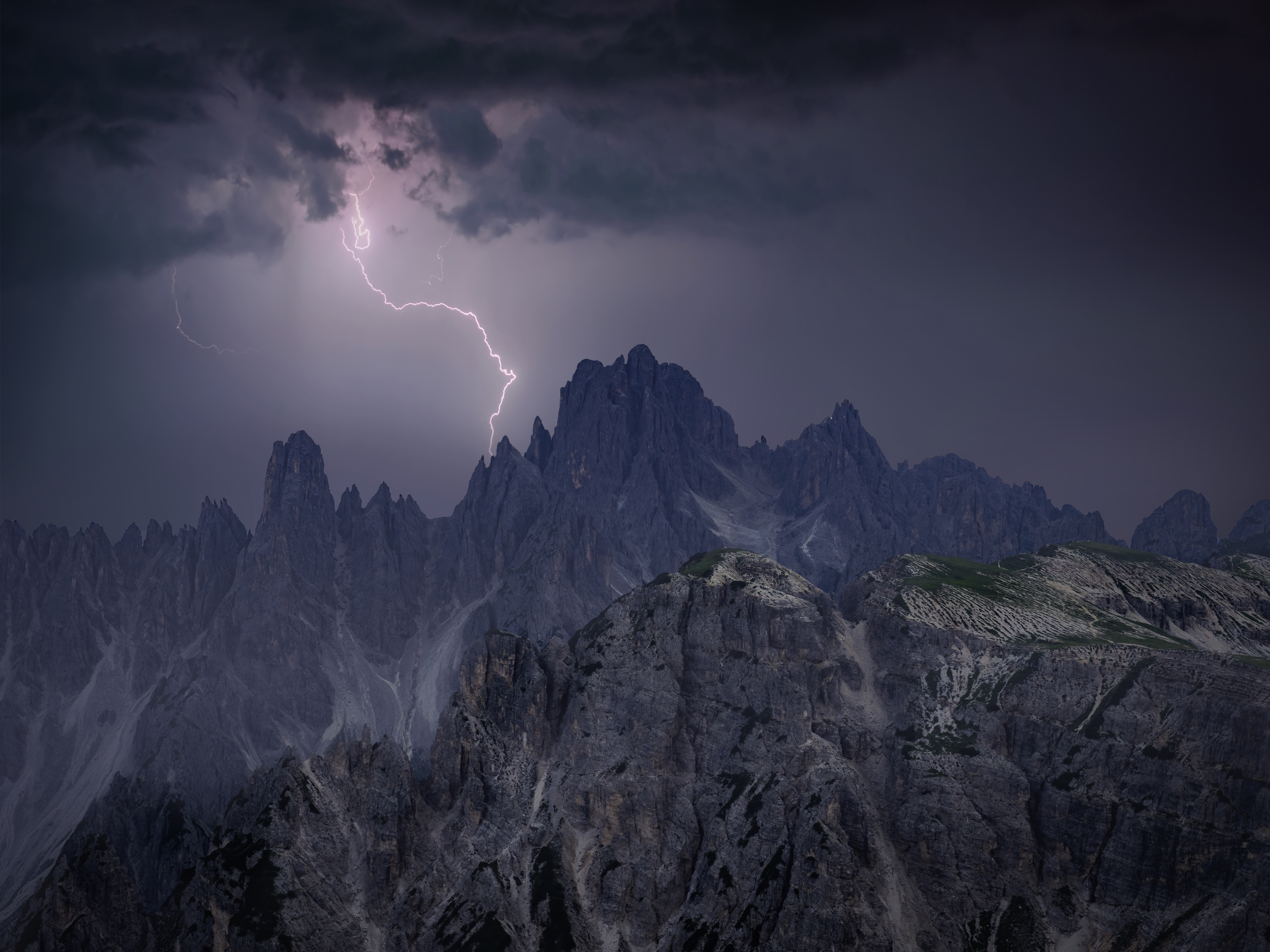 Ein Blitz schlägt über einem Berggipfel ein.