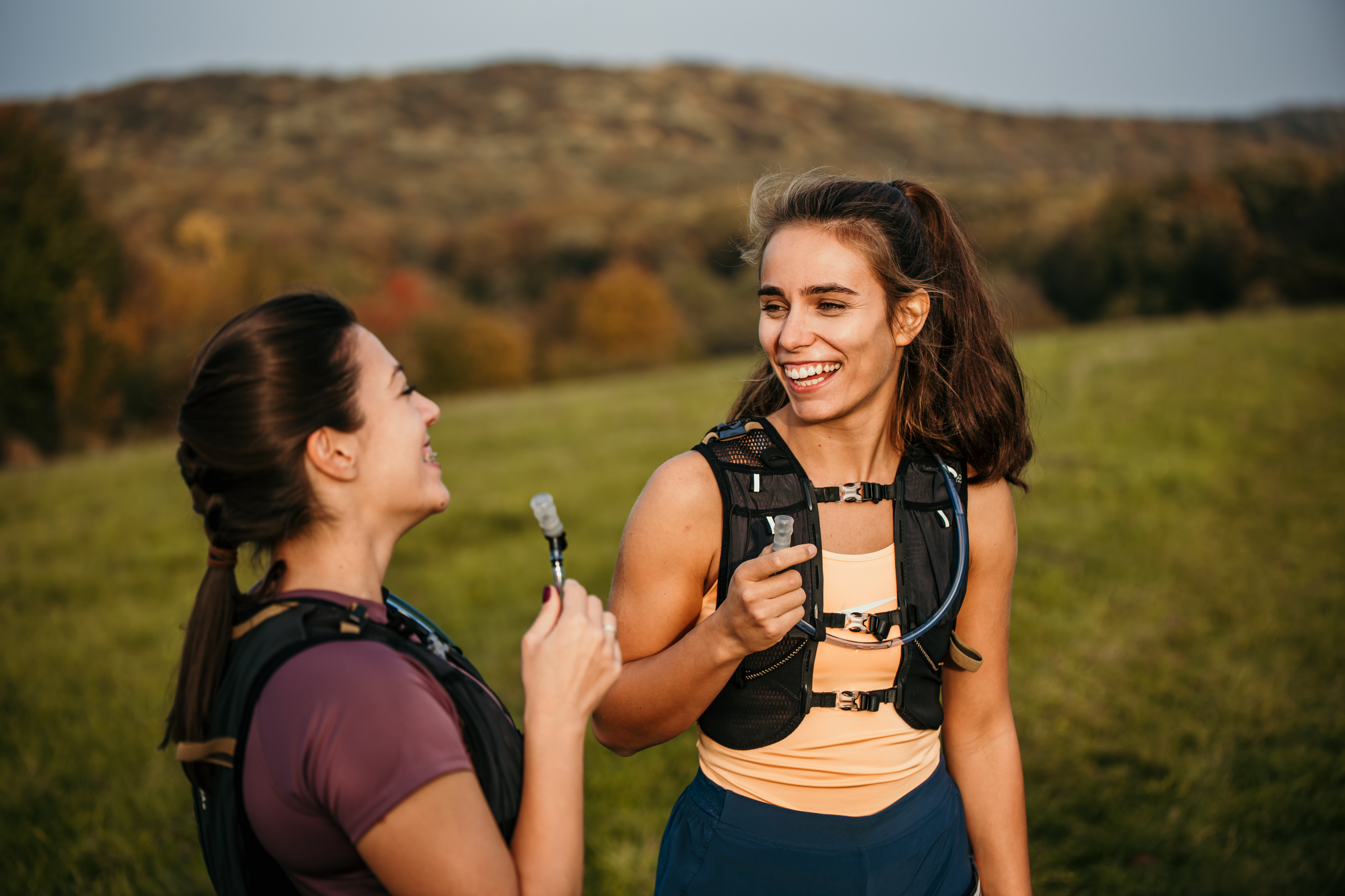 Zwei Frauen beim Trailrunning trinken aus ihren Trinksystemen