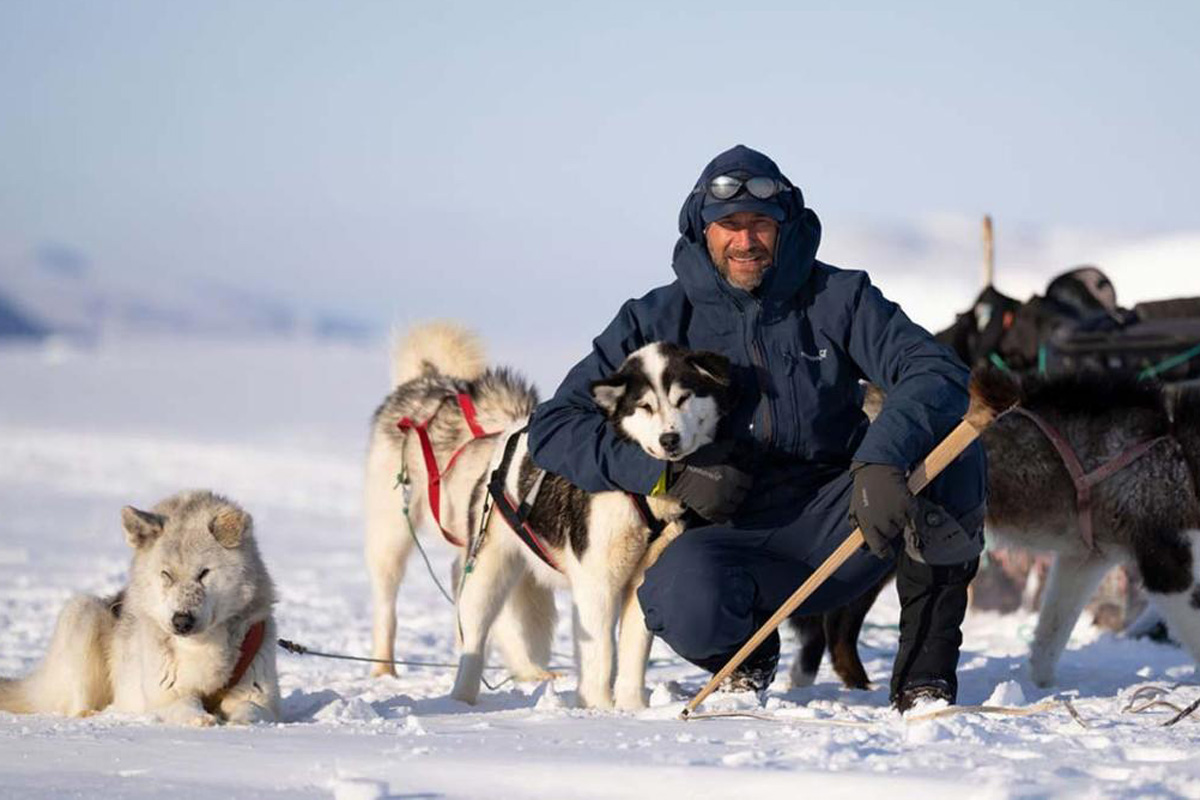 Der Polarforscher, Klimaanalytiker und Fotograf Sebastian Copeland vor Huskys in Grönland.
