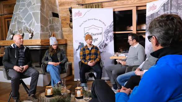 Die Teilnehmer der Podiumsdiskussion diskutieren zusammen.