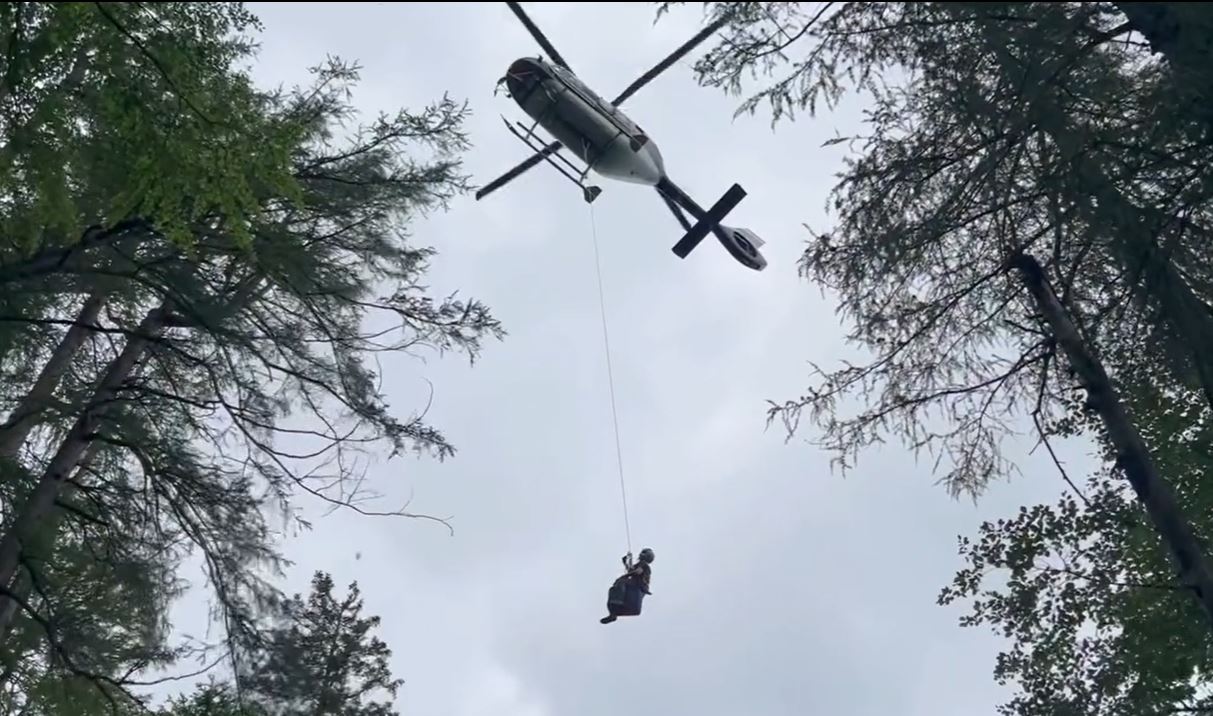 Ein Bergretter der Bergrettung Bad Ischl seilt sich von einem Helikopter ab.