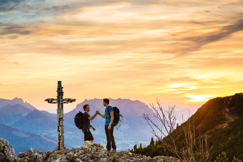 Nach dem Hinlangen ein Handschlag am Gipfel der Hörndlwand