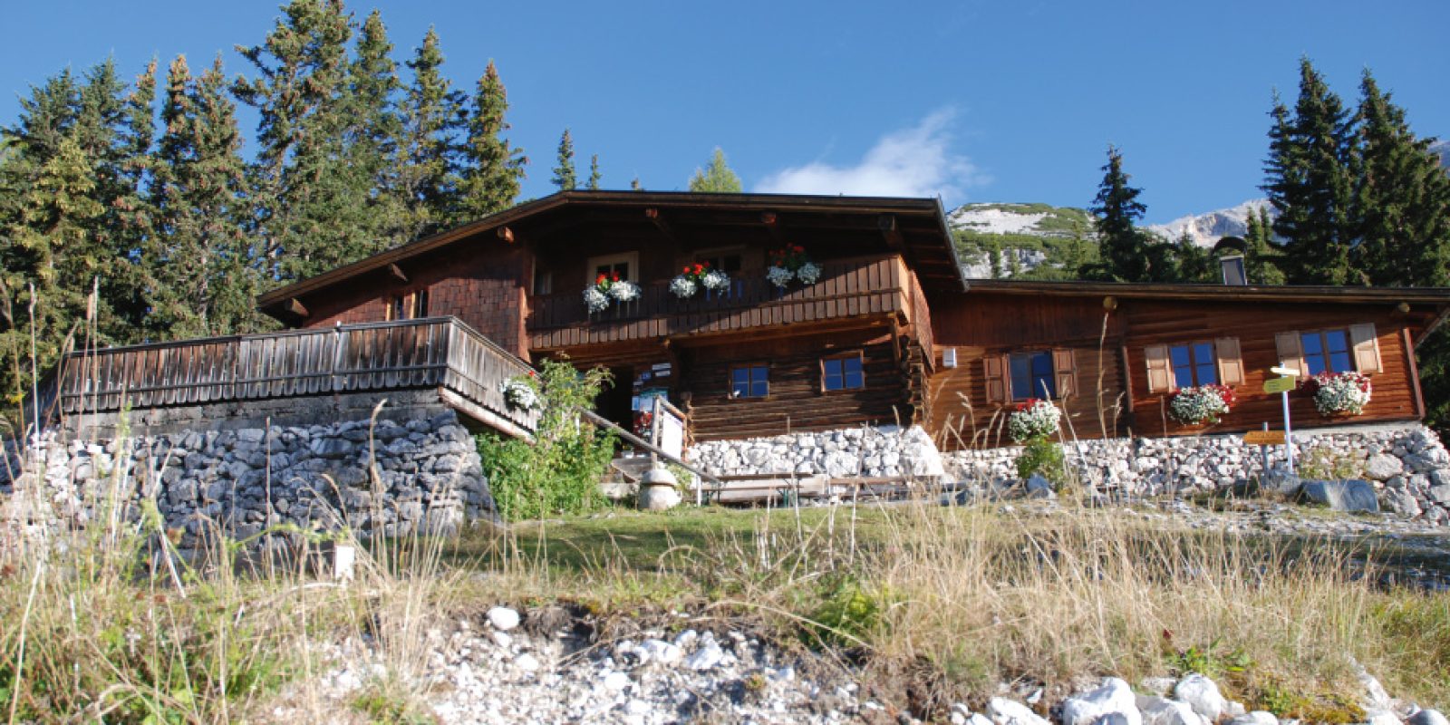 Schon vormittags scheint die Sonne auf die Terrasse der Pleisenhütte über Scharnitz